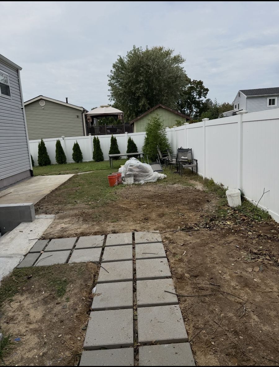 Cleared backyard with a paver walkway